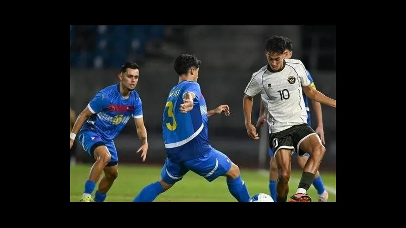 Cầu thủ U22 Indonesia với áo đỏ đang nỗ lực cản phá cầu thủ U22 Myanmar đang đi bóng.